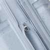 Close-up of a light blue Samsonite suitcase with a zipper on a speckled gray background
