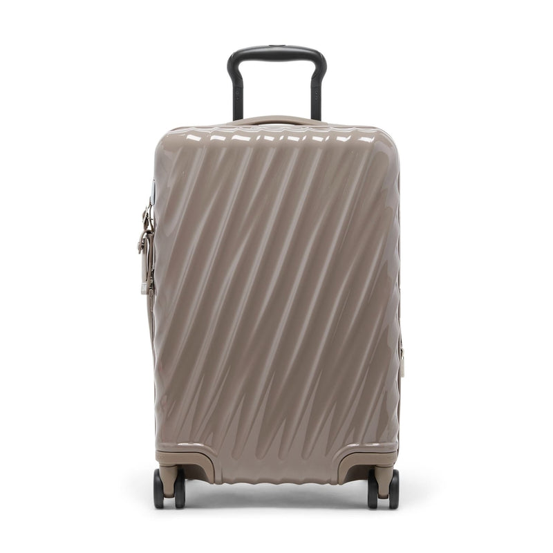 Beige TUMI suitcase with a black handle on a white background