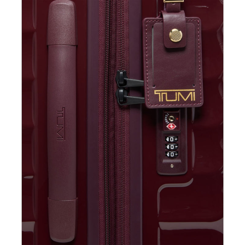 Maroon TUMI suitcase with a luggage tag and handle