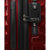 Red TUMI suitcase with black handle and tag on a red background