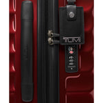 Red TUMI suitcase with black handle and tag on a red background