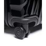 Close-up of a black TUMI suitcase with wheels on a white background