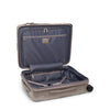 Open beige TUMI suitcase with a white background