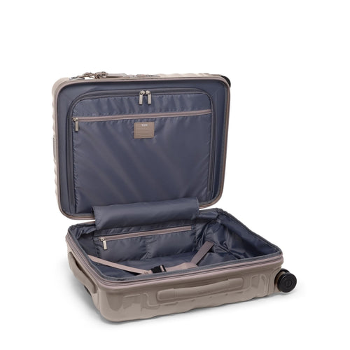 Open beige TUMI suitcase with a white background