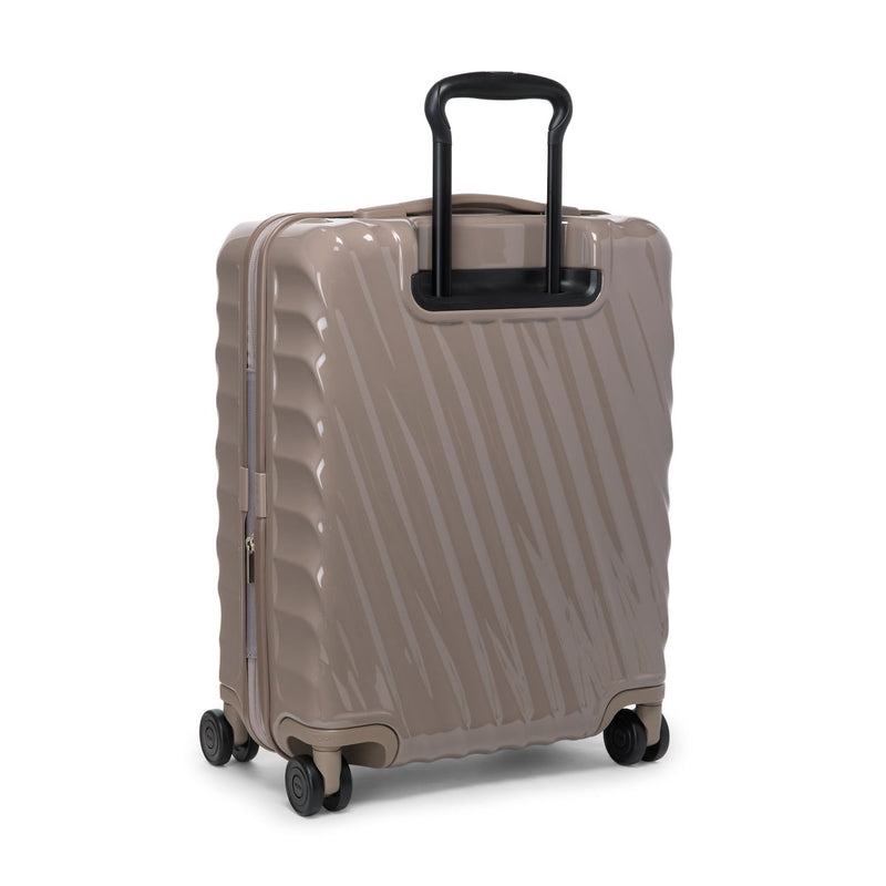Beige TUMI suitcase with a black handle on a white background
