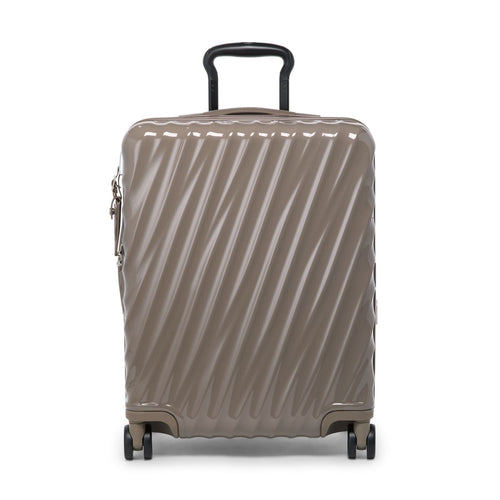 Beige TUMI suitcase with a textured pattern on a white background