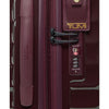 Close-up of a maroon TUMI suitcase with a visible brand logo.
