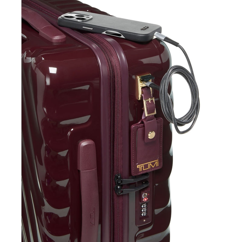 Maroon TUMI suitcase with a security cable and device attached on a white background