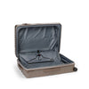 Open beige TUMI suitcase on a white background