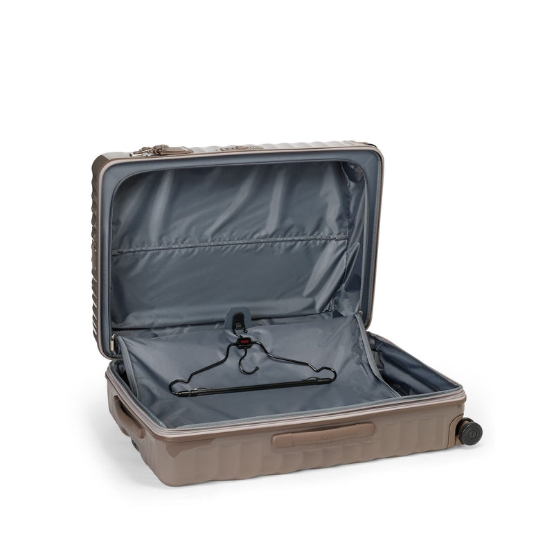 Open beige TUMI suitcase on a white background