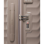 Close-up of a beige TUMI suitcase with a handle and combination lock.