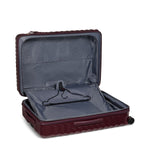 Open burgundy TUMI suitcase with gray interior on a white background