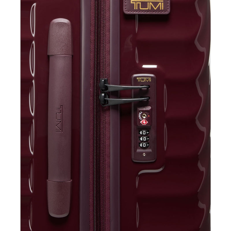 Maroon TUMI suitcase with lock on a white background