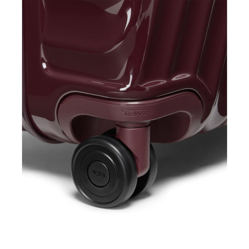 Close-up of a maroon TUMI suitcase with a visible brand logo on a white background