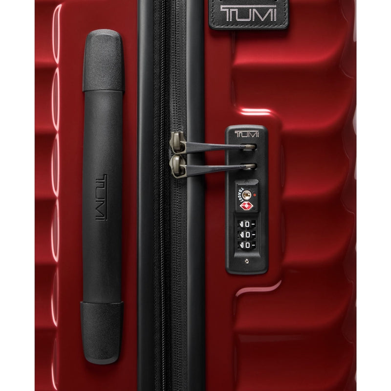 Red TUMI suitcase with black handle and combination lock