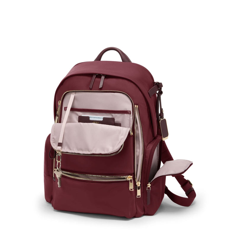 Wine TUMI backpack with gold zippers on a white background