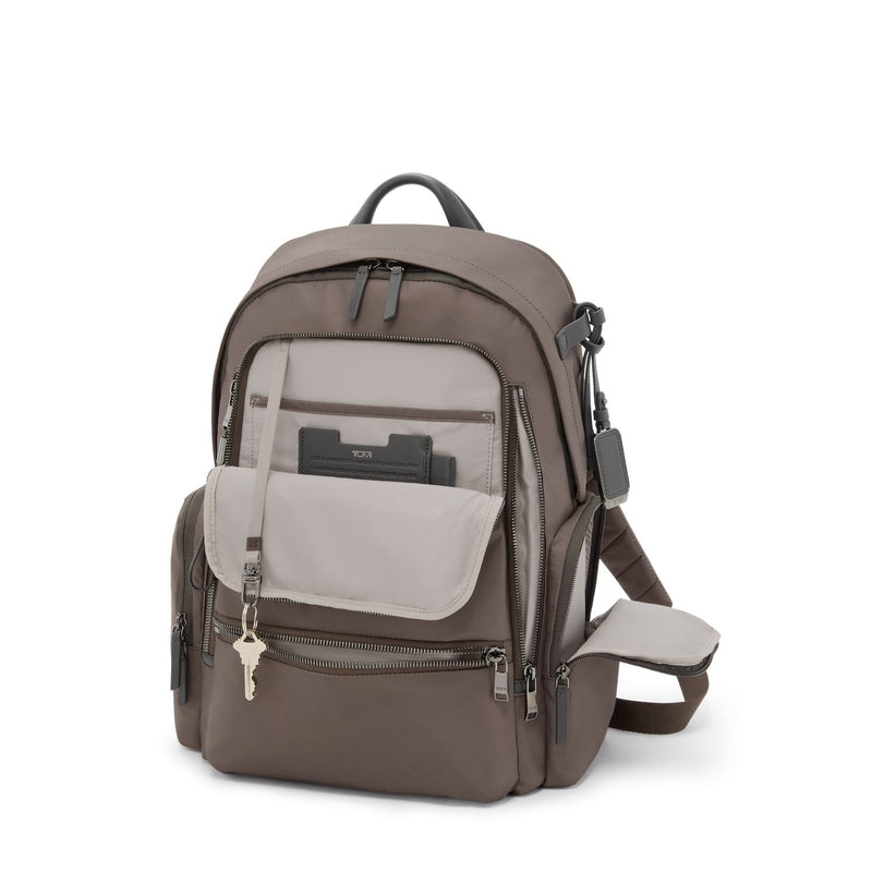 Mink TUMI backpack with multiple pockets and a key attached on a white background