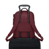 Wine TUMI backpack with black suitcase on a white background