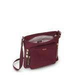 Wine TUMI handbag with gold accents on a white background