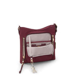 Wine TUMI crossbody bag with gold zippers on a white background