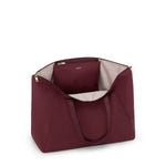 Wine TUMI handbag with gold zipper on a white background