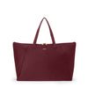 Wine TUMI tote bag with a gold zipper on a white background