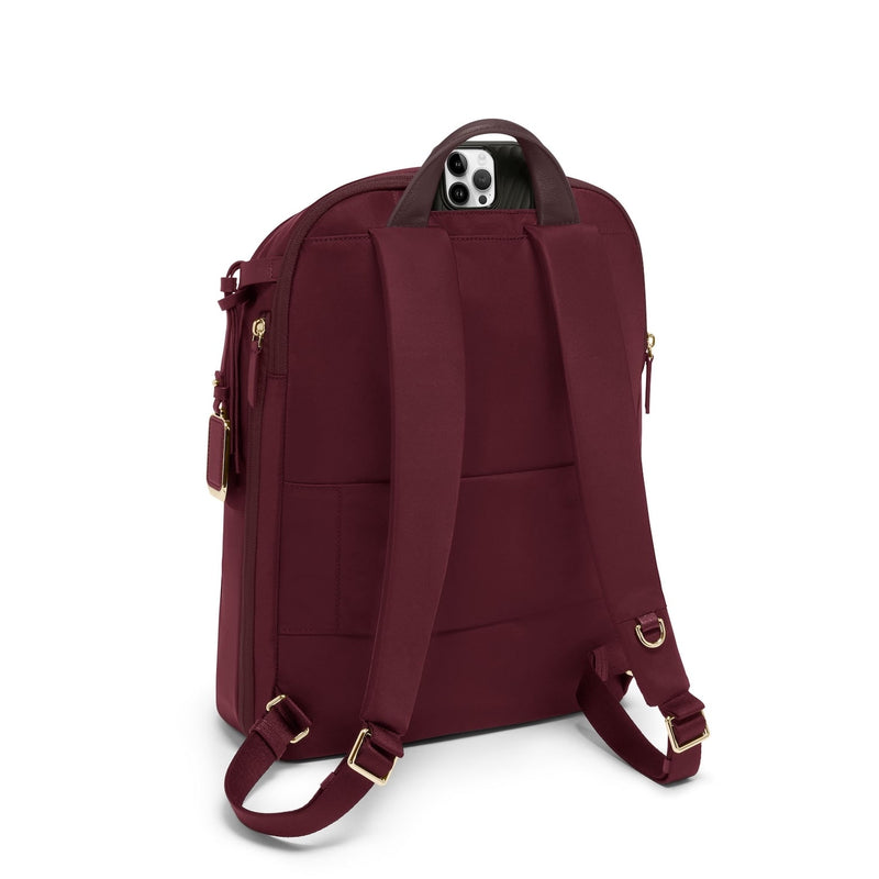 Maroon TUMI backpack with gold zippers on a white background