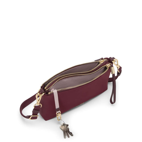 Wine TUMI handbag with gold accents on a white background