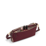 Wine TUMI handbag with gold zippers on a white background
