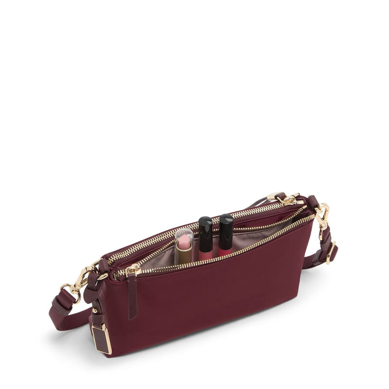 Wine TUMI handbag with gold zippers on a white background