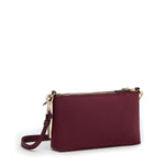 Wine TUMI handbag with gold zipper and strap on a white background