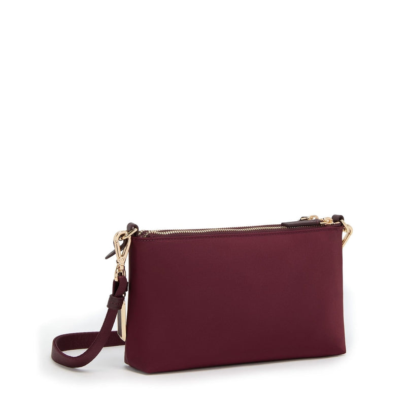 Wine TUMI handbag with gold zipper and strap on a white background