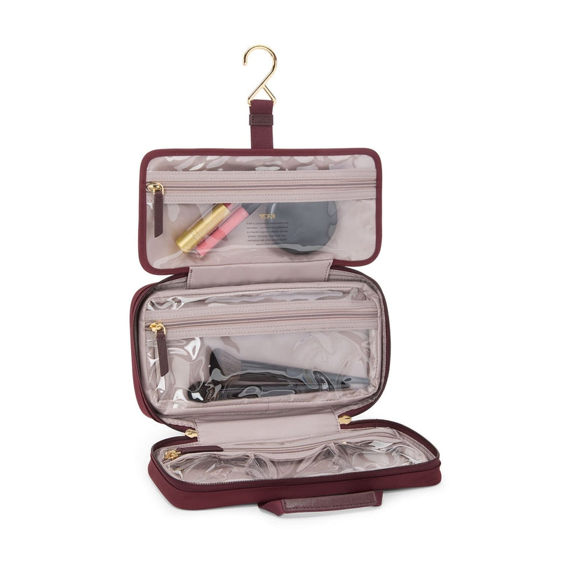 TUMI Travel toiletry bag with clear compartments on a white background