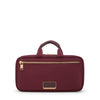Wine TUMI toiletry bag with gold zipper and accents on a white background