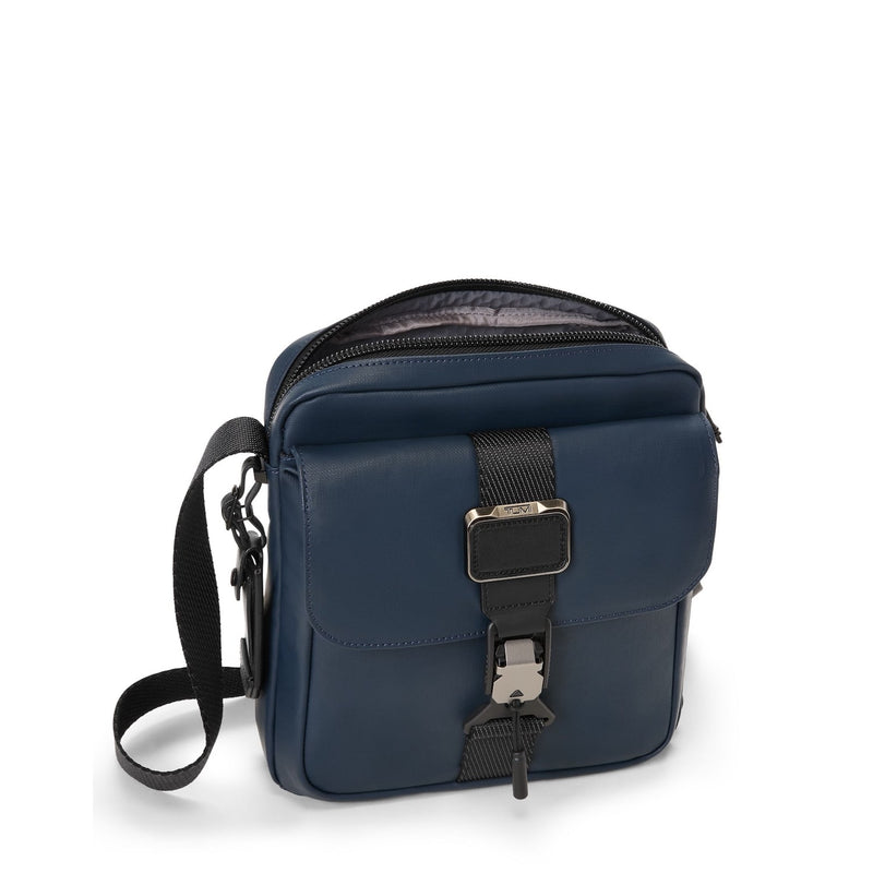 Navy blue TUMI crossbody bag with black strap on a white background