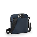 Navy blue TUMI crossbody bag with a phone case on a white background