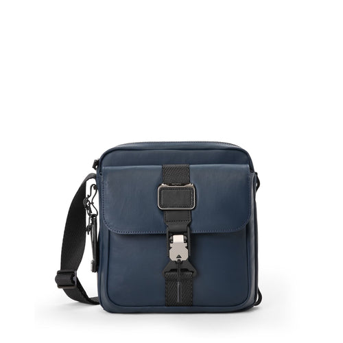 Navy blue TUMI shoulder bag with black straps on a white background