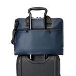 Blue TUMI briefcase with black handle on a white background