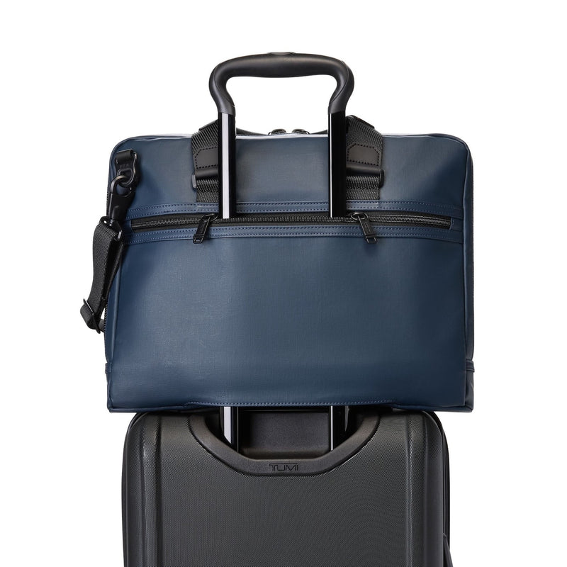Blue TUMI briefcase with black handle on a white background