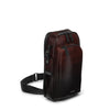 Brown TUMI leather bag with black straps on a white background