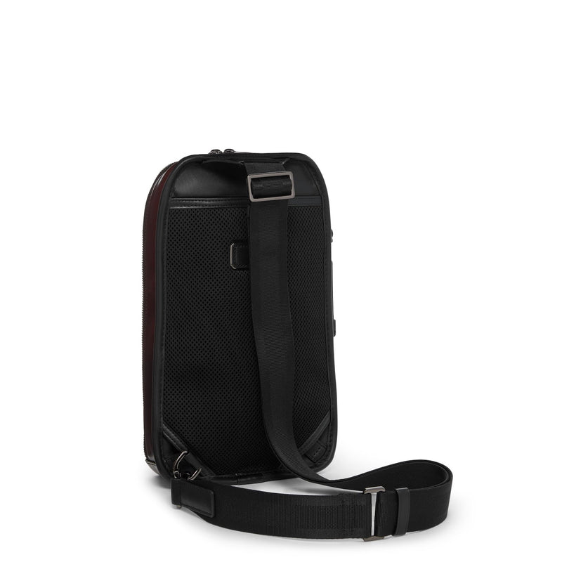 Black TUMI crossbody bag on a white background