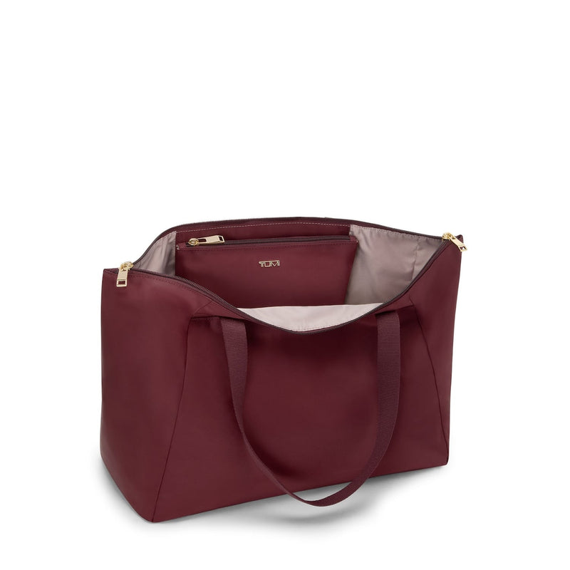 Wine TUMI tote bag with gold zipper on a white background