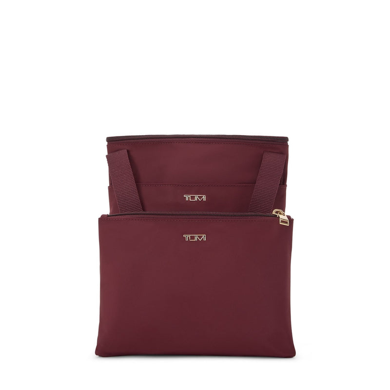 maroon TUMI bag with gold zippers and 'TUMI' branding on a white background