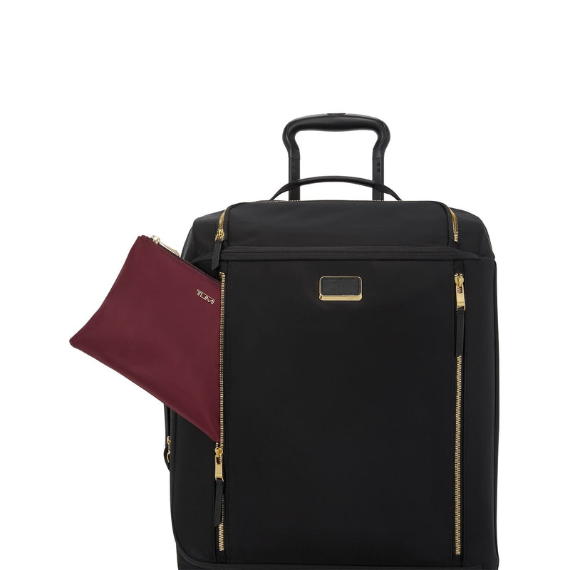 Black TUMI suitcase with gold accents and a matching maroon pouch on a white background
