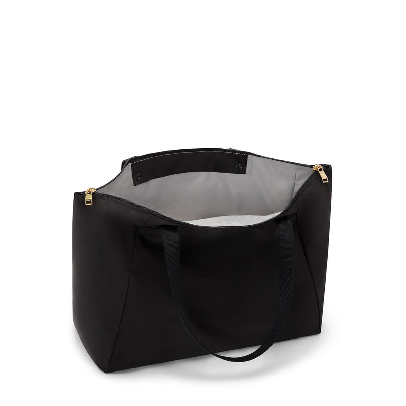 Black TUMI tote bag with gold zipper on a white background