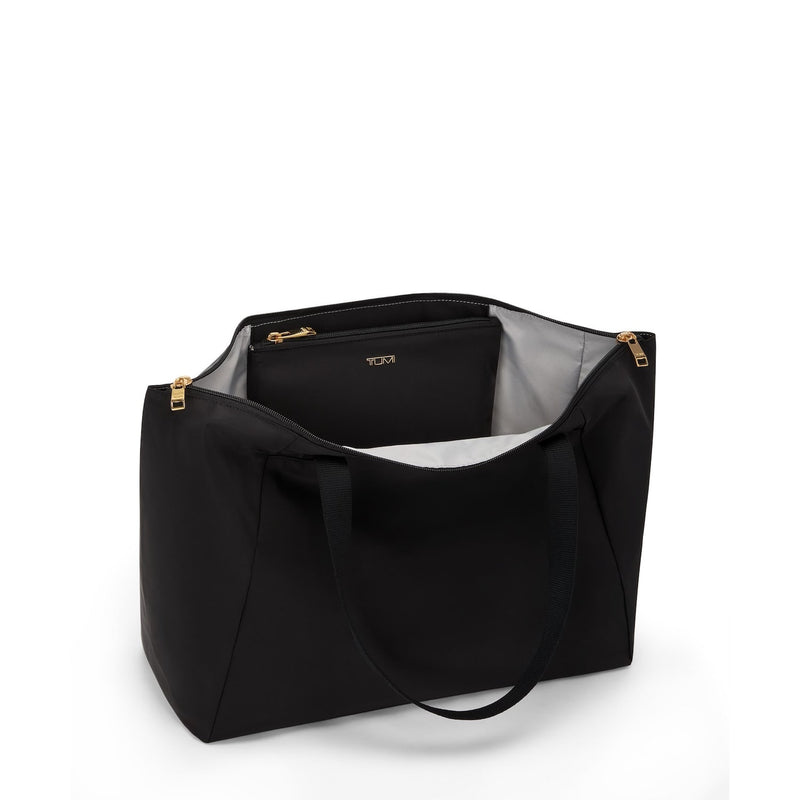 Black TUMI handbag with gold zippers on a white background