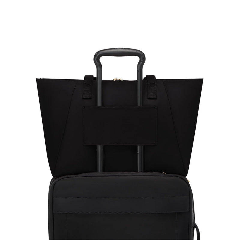 Black TUMI suitcase with handle and wheels on a white background