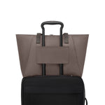Mink TUMI tote on suitcase with black handle on a white background