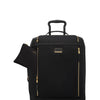 Black TUMI suitcase with gold zippers and handle on a white background