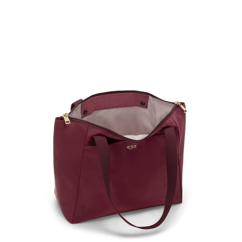 Wine TUMI handbag with gold zipper on a white background